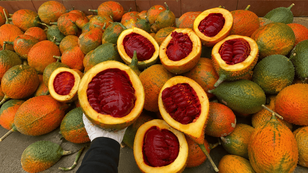Fresh gac fruit cut open to show its deep red centre